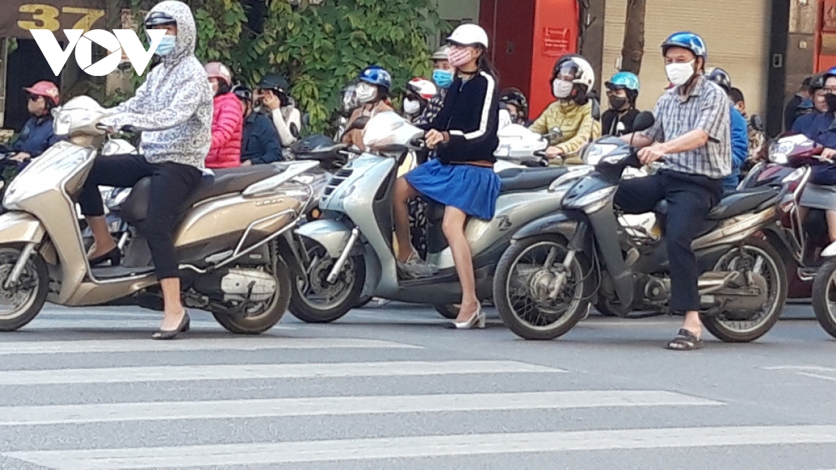 Locals follow face mask rules in public areas throughout Hanoi